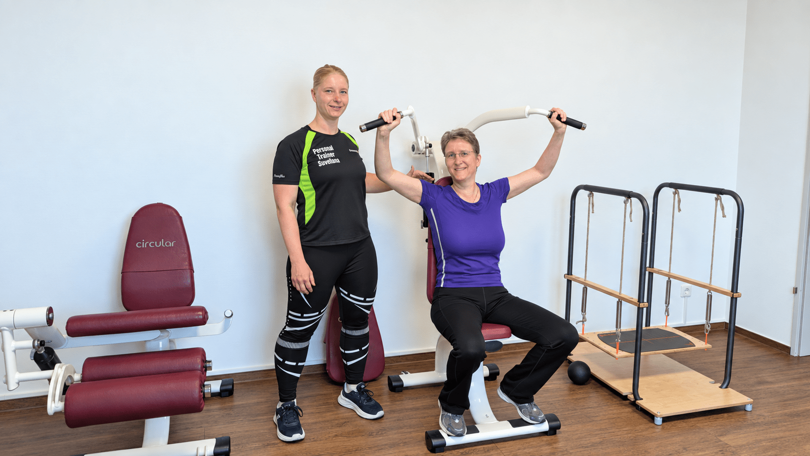 Personal Trainerin Swetlana begleitet eine Kundin beim Schultertraining an einem Fitnessgerät in Essen